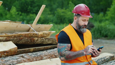 A-bearded-builder-in-a-helmet-uses-a-smartphone-3