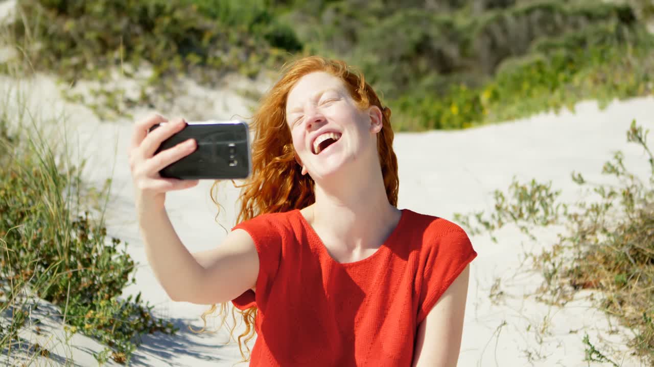 mujer tomando una selfie con teléfono móvil en la playa 4k