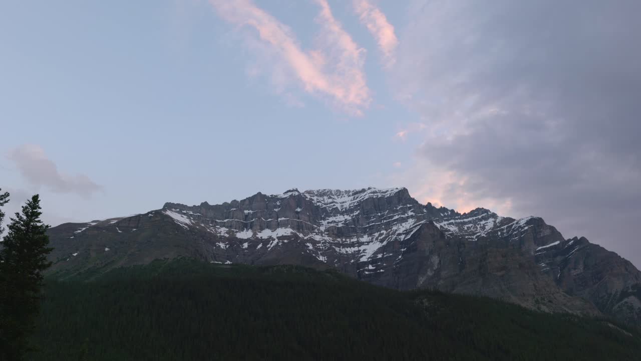 Snedækkede tinder i de canadiske Rocky Mountains under en fredfyldt morgenhimmel.