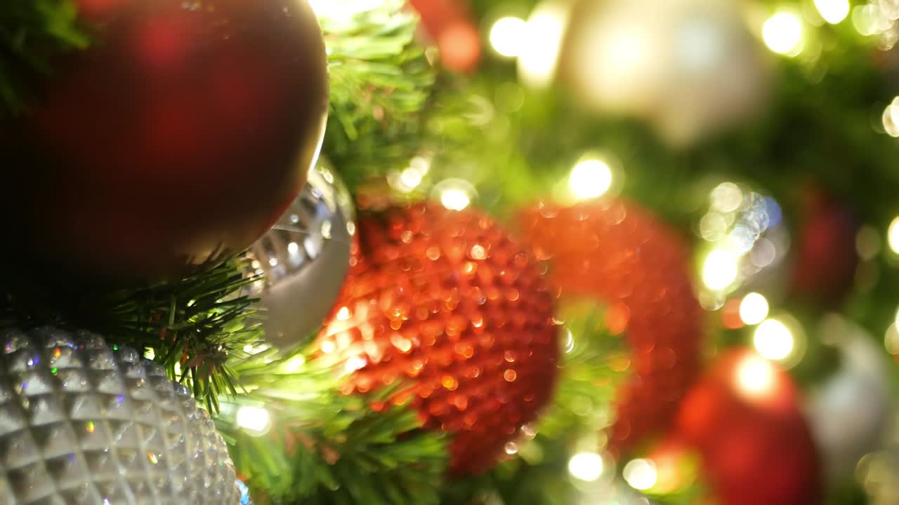 축제로 장식 된 야외 크리스마스 트리의 클로즈업 - 흐릿한 반이는 요정 배경에 밝은 은 공 - 초점을 맞추지 않은 꽃받침 조명, 보케 효과 - 메리 크리스마스 및 행복한 휴가 개념.