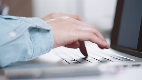 fotografía de cerca de las manos de una mujer de negocios escribiendo en el teclado de una computadora portátil para buscar información, soporte de comunicación en línea, investigación de mercadotecnia, informe de negocios en el escritorio de la oficina por la noche.