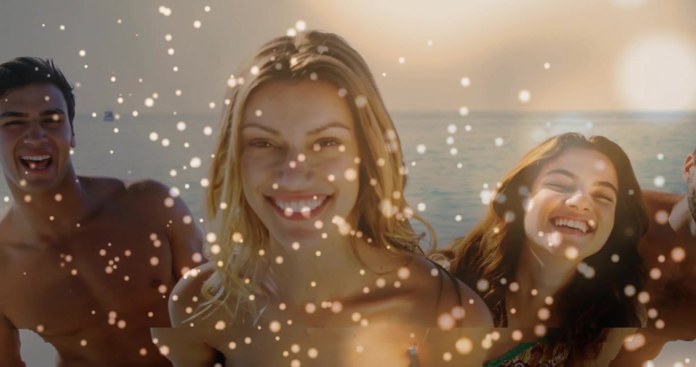 Mulher inclinada ao centro, de biquíni azul tomara que caia, posando para a câmera e sorrindo na praia enquanto o sol cintila