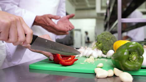 chef cortando verduras en una tabla verde