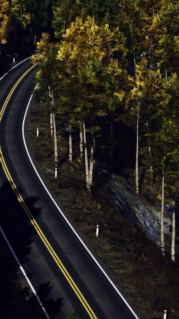 Winding road through vibrant autumn trees surrounded by tranquil scenery