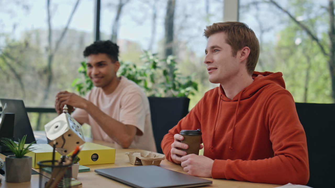 웃는 동료들이 커피를 마시며 사무실 휴식을 즐기고 있습니다. 팀이 이야기합니다.