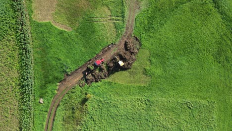 Von-Oben-Nach-Unten-Auf-Einem-Bagger,-Der-Erde-Auf-Der-Wiese-Aushebt