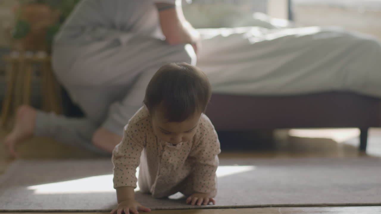 adorable bebé en pijama arrastrándose por el suelo en casa