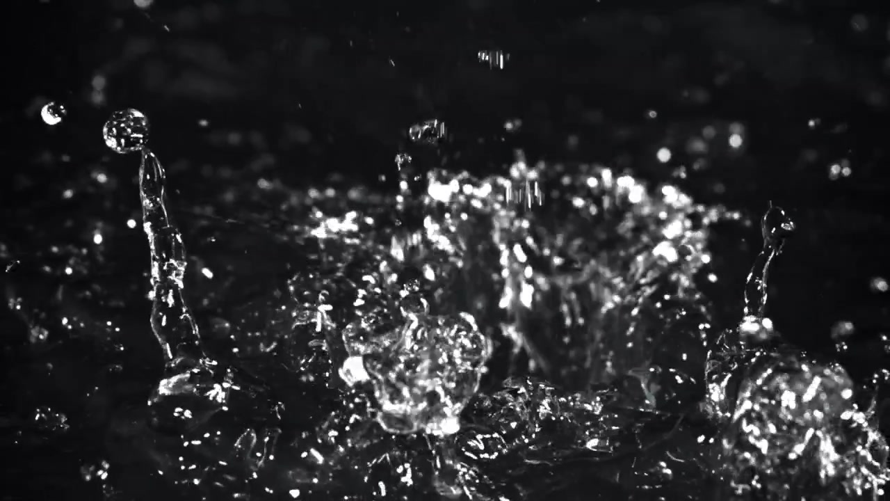 Clear Water Droplets Splashing and Rippling on a Dark Background in Slow Motion