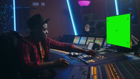 elegante ingeniero de audio productor que trabaja en un estudio de grabación de música, utiliza computadora de pantalla verde, ecualizador de placa de mezcla y escritorio de control para crear nuevas canciones y canciones de éxito. artista músico. retrato de vista lateral