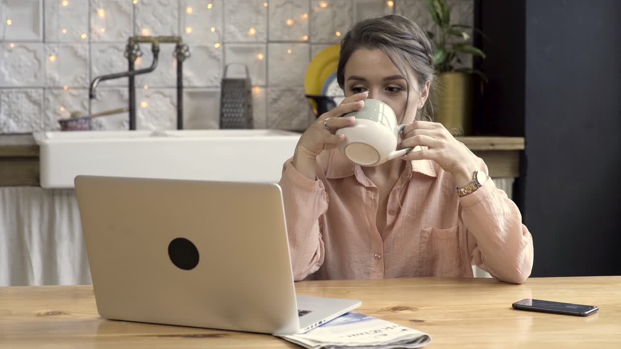mujer trabajando desde casa, bebiendo café