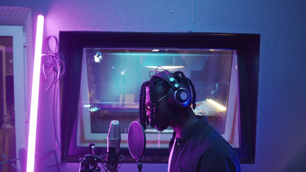 cantante afroamericano grabando una canción en el estudio