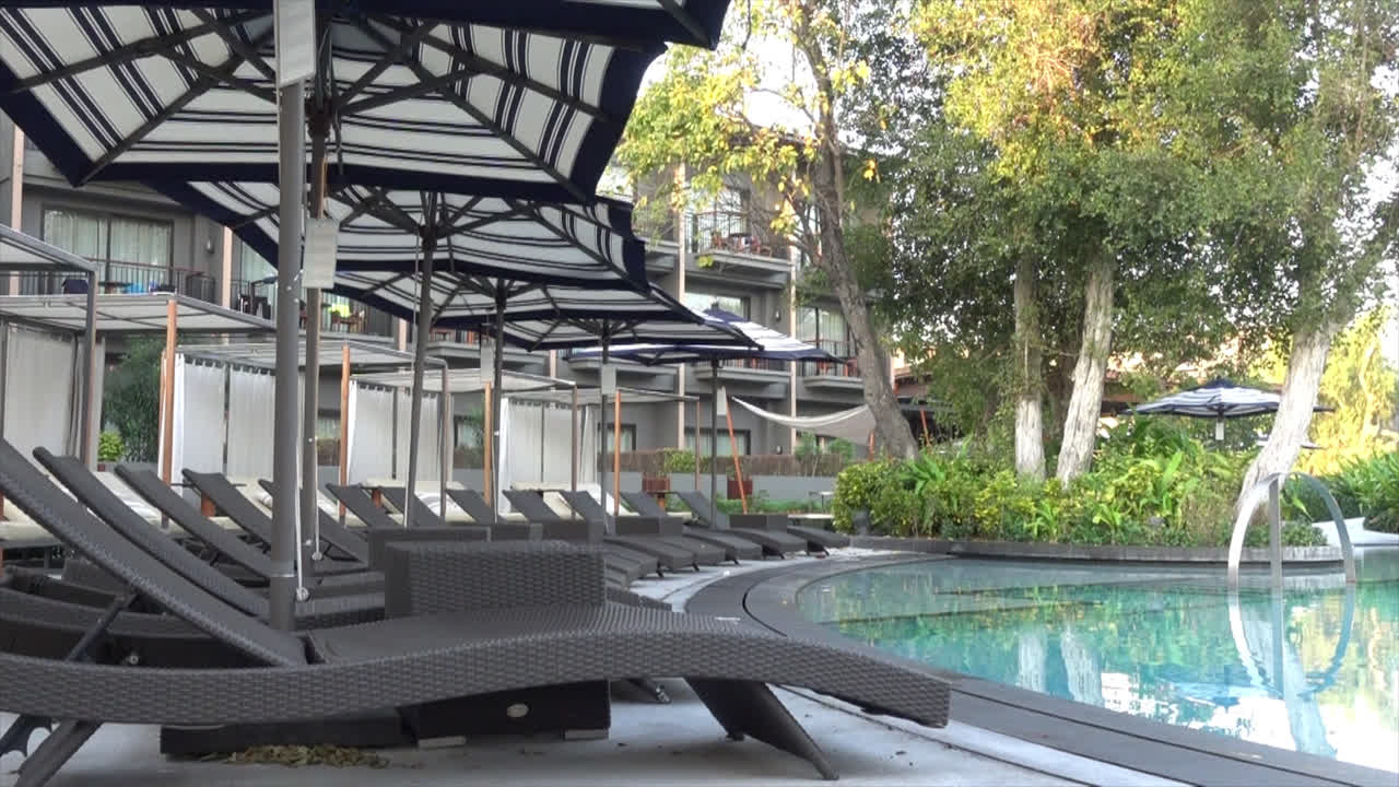 휴가 개념을 위한 호텔 리조트의 수영장 주변에 파라솔이 있는 침대 수영장