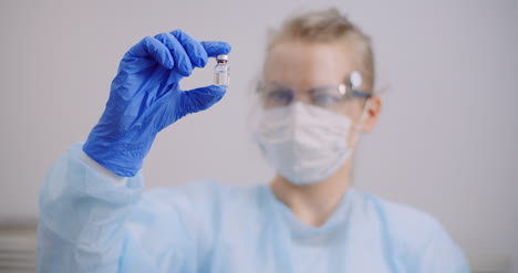 Female-Scientist-Holding-Tubes-And-Flask-With-Liquid-In-Hands-2