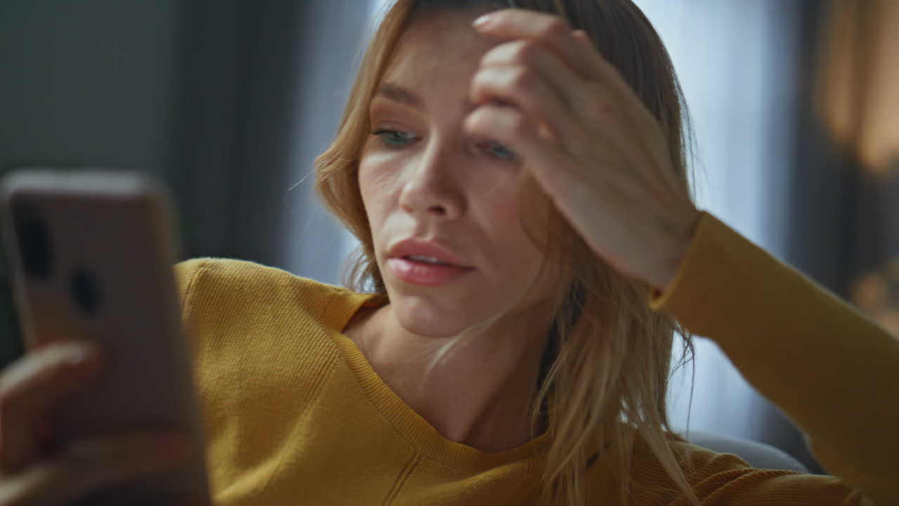 Sleepy woman receiving sms at sofa closeup. Excited lady reading phone message
