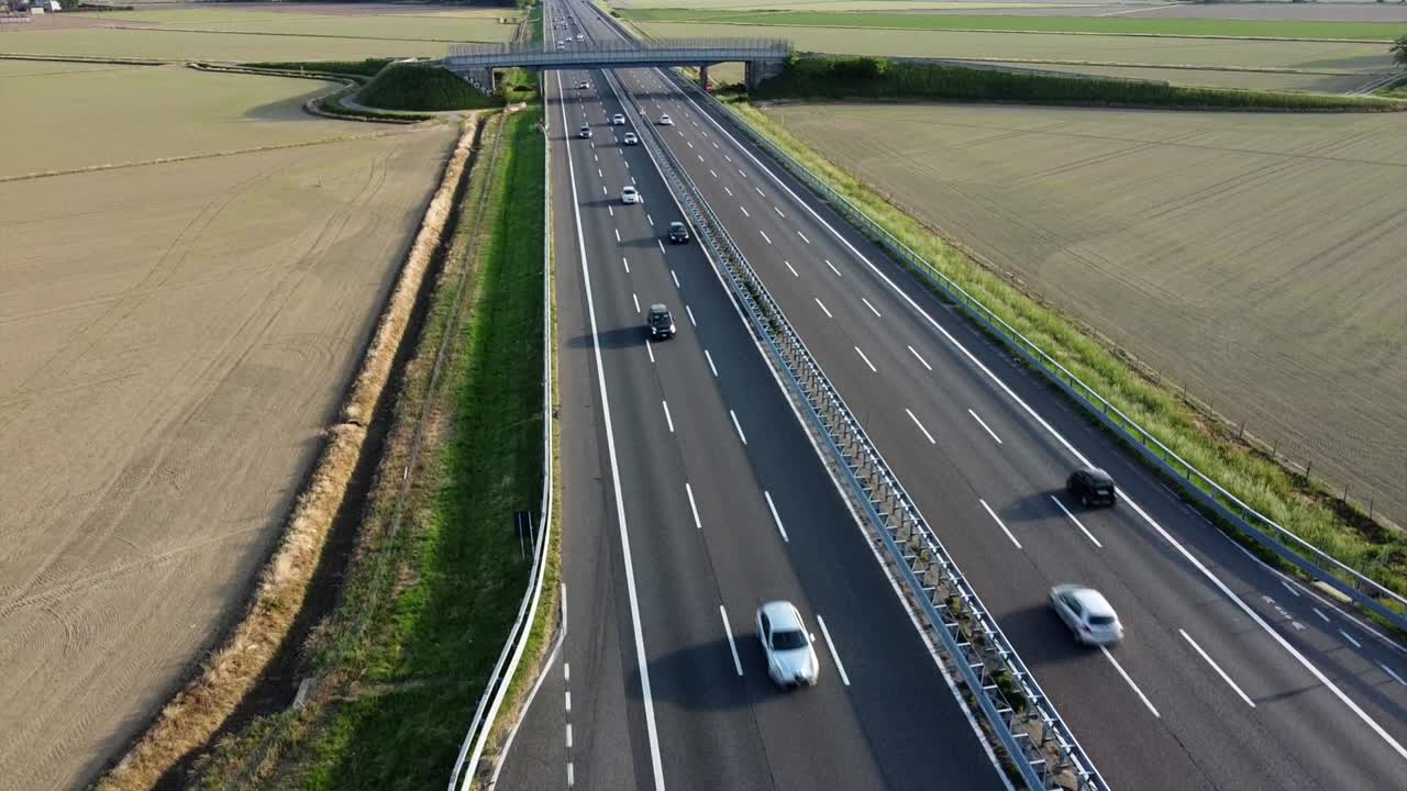 view from the drone of a new light pylon for the passage of high voltage electricity in countryside landscape and traffic car highway - increase in the cost of electricity energy  and green revolution