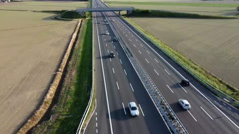 view from the drone of a new light pylon for the passage of high voltage electricity in countryside landscape and traffic car highway - increase in the cost of electricity energy  and green revolution