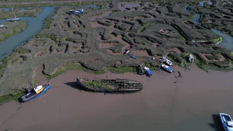 Mooring-Boats-And-Shipwreck-At-Marshes-In-Tollesbury-Marina,-Essex,-United-Kingdom