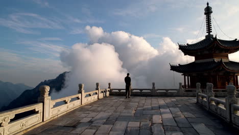 person gazing at clouds from a mountain pagoda viewpoint