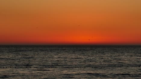 Toma-Estática-De-Un-Impresionante-Cielo-Naranja-Desde-Una-Vibrante-Puesta-De-Sol-Sobre-El-Océano-En-Iquique