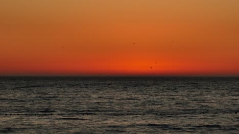 toma estática de un impresionante cielo naranja desde una vibrante puesta de sol sobre el océano en iquique
