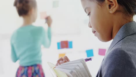 kid as businesswoman writing on diary 4k