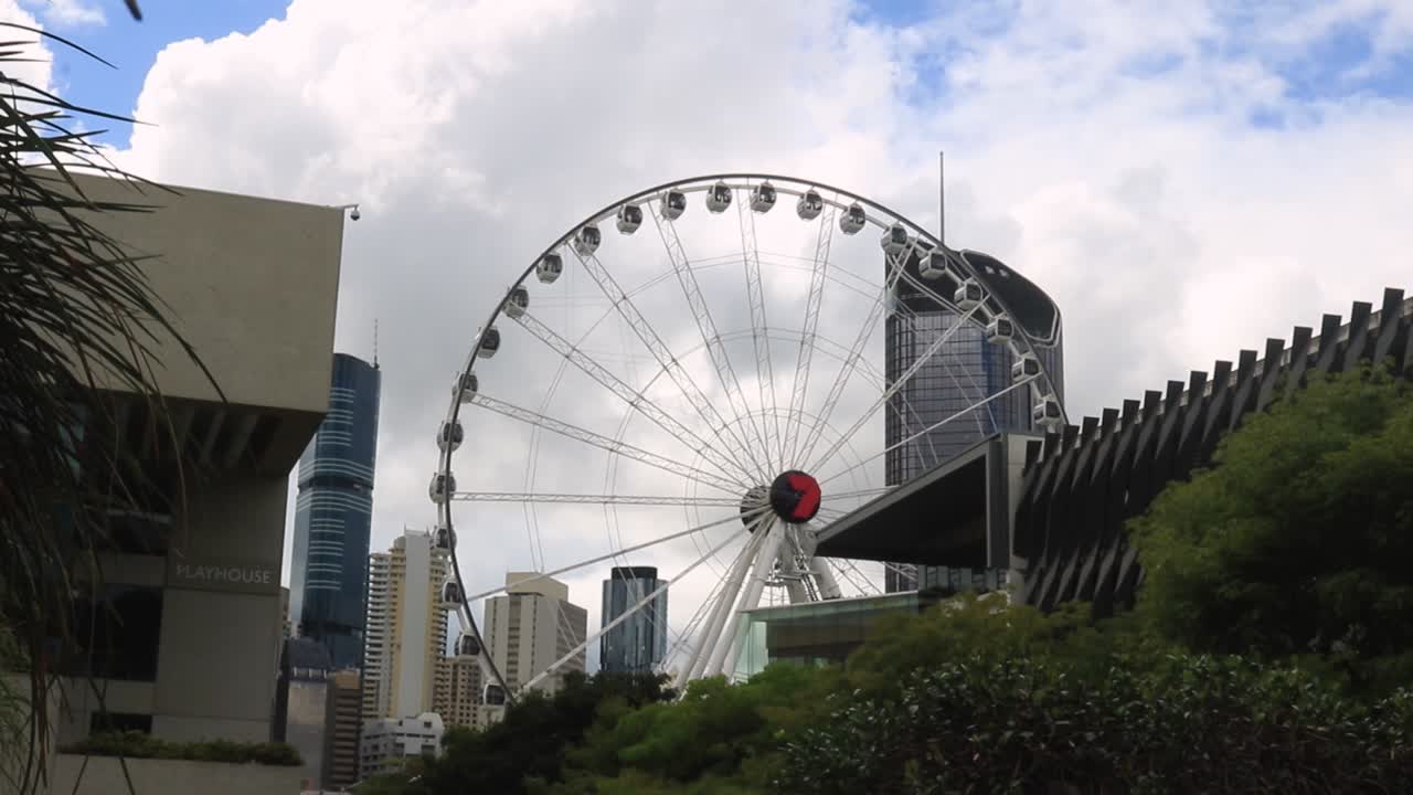 Wheel of Brisbane slightly obscured by buildings in the foreground.
