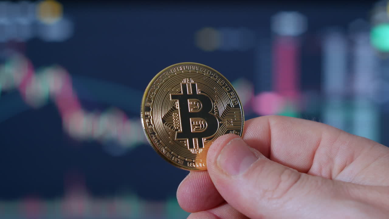 un retrato de la moneda de oro bitcoin btc ada que se sostiene en la mano con gráficos comerciales en el fondo