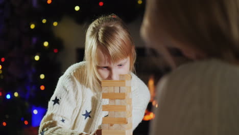 a child with a parent plays a board game christmas holidays with kids