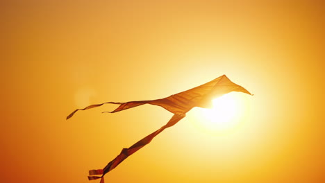 una cometa vuela en los rayos del sol poniente concepto de infancia y sueños