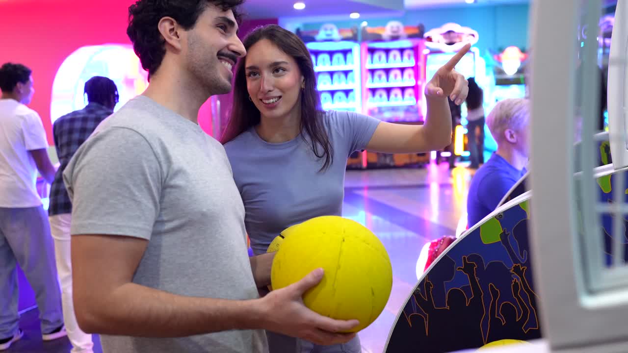 Coppia che gioca a basket con un videogioco arcade