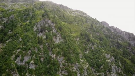 aerial drone view of the rocky facade of a mountain in the swiss alps