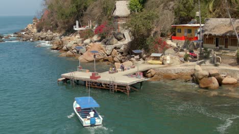 Drohne-Folgt-Einem-Wassertaxi,-Das-Im-Sommer-Am-Pier-In-Yelapa,-Jalisco,-Mexiko-Ankommt