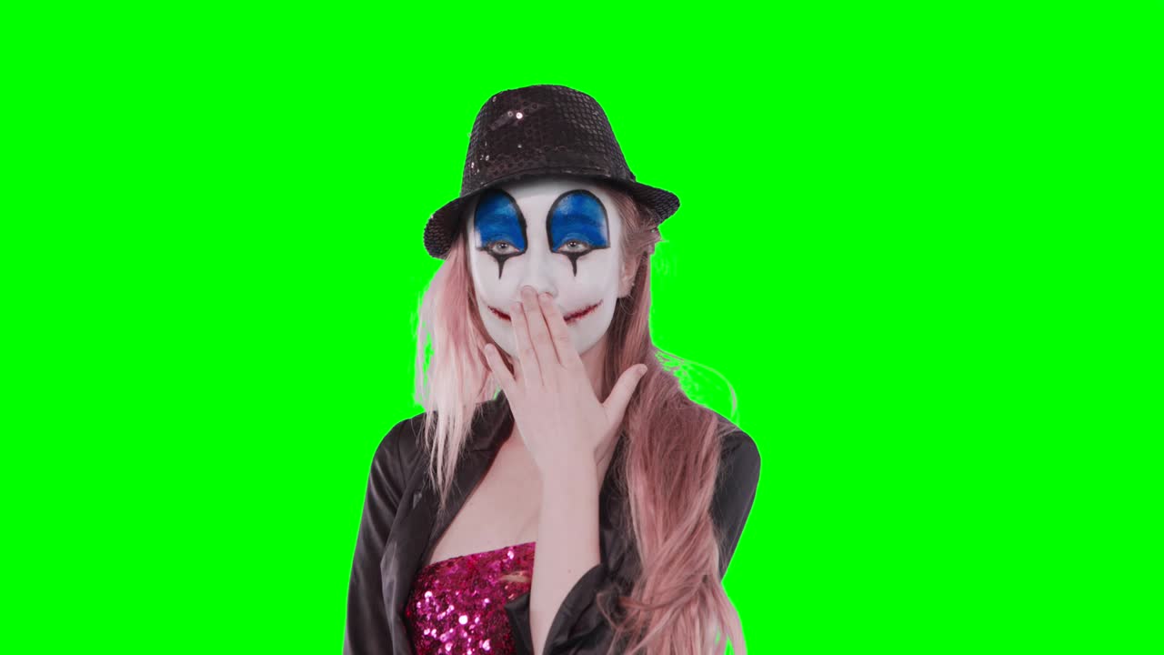 la payasa juega con su cabello riéndose de la cámara.