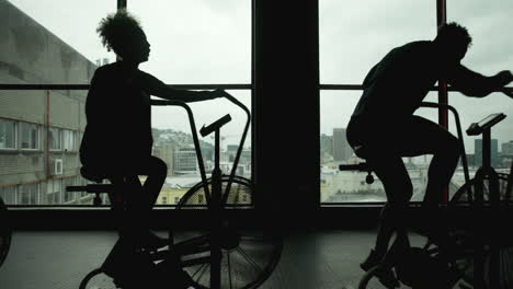 people exercising on stationary bikes in gym