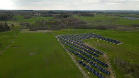 aerial backwards shot of powerful eco friendly solar energy farm surrounded by rural agricultural fields