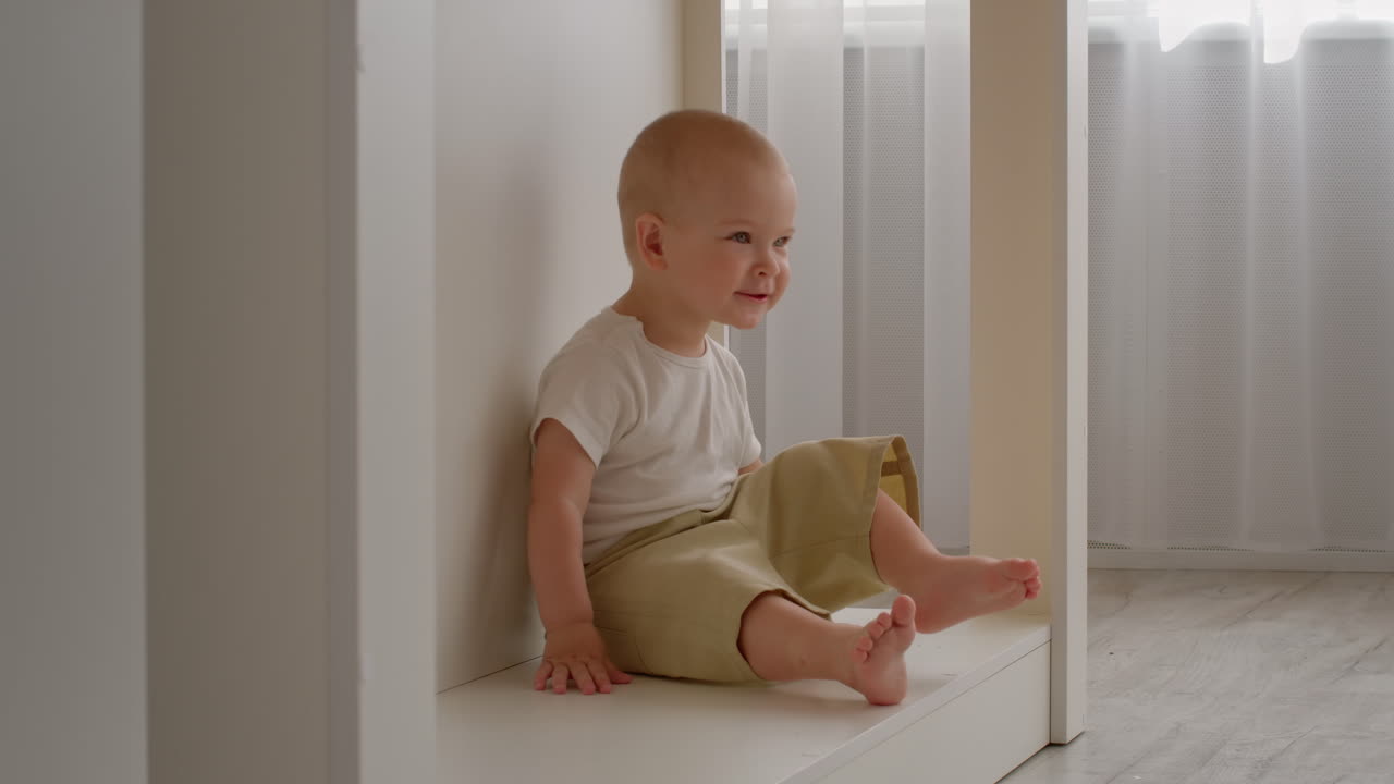 bebé feliz sentado en el estante