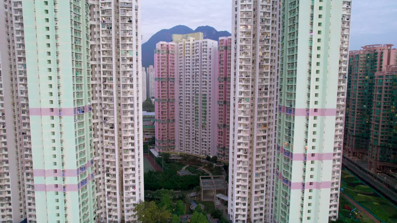 Torres de apartamentos altas nas cores verde e rosa com jardins artificiais verdes no densamente povoado Ma On Shan, nos Novos Territórios de Hong Kong.