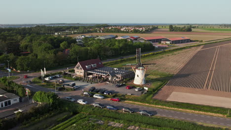 Drone-Aéreo-Del-Restaurante-Pfannkuchenhaus-De-Molen-Con-El-Tradicional-Molino-De-Viento-Holandés-En-Scharendijke,-Países-Bajos