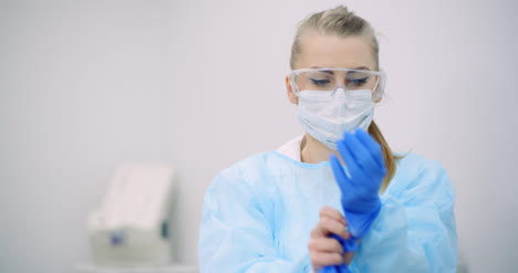 el médico pone guantes protectores azules en las manos en la clínica de atención médica