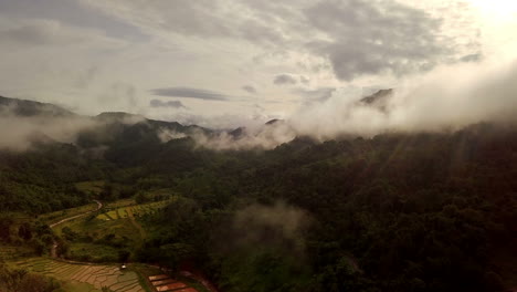 aerial view flying above lush green tropical rain forest mountain with rain cloud cover during the rainy season on the doi phuka mountain reserved national park the northern thailand