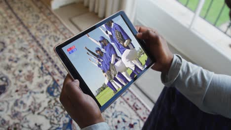 Compuesto-De-Un-Hombre-Sentado-En-Casa,-Viendo-Un-Partido-De-Béisbol-Durante-El-Covid-19-En-Una-Tableta