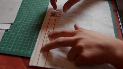 using a ruler to measure and mark fabric on a cutting board. slow motion.