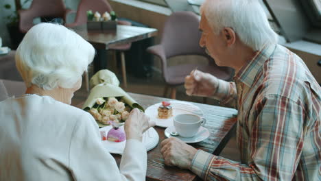 elderly couple enjoying dessert at a cafe