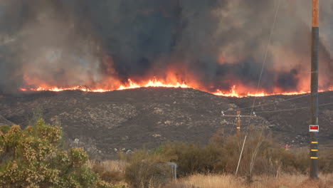 llamas masivas y nubes de humo cubren la cresta de la colina en hemet, california