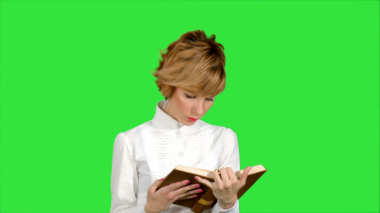 초록색 스크린, 크로마 키에 책을 들고 읽는 집중된 젊은 사업가