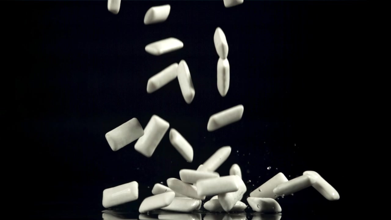 Pezzi di chewing gum bianchi che cadono al rallentatore