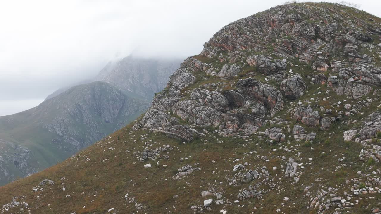 A stunning close-up of a prominent mountain peak at Outeniqua Pass, captured by a DJI Air 3 drone. The smooth pan to the right reveals breathtaking textures and rugged beauty.