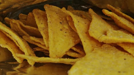 smooth receding shot of delicious tortilla chips contained in a potato chip bag