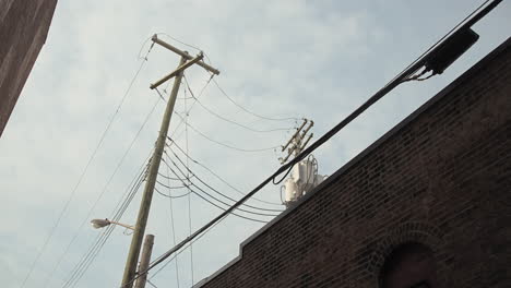 Poste-De-Energía-Entre-Dos-Edificios-Mirando-Hacia-Arriba