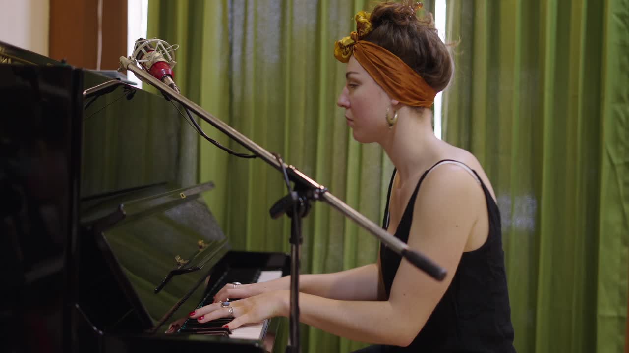 Woman Playing Piano with Microphone in Studio